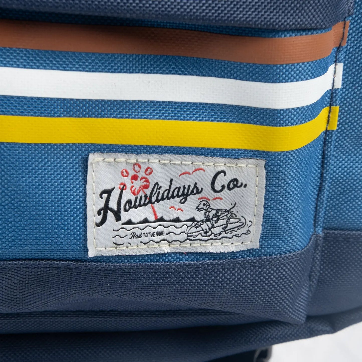 Close-up of the woven label featuring a surfing skull dog, embodying an adventurous and free-spirited lifestyle.